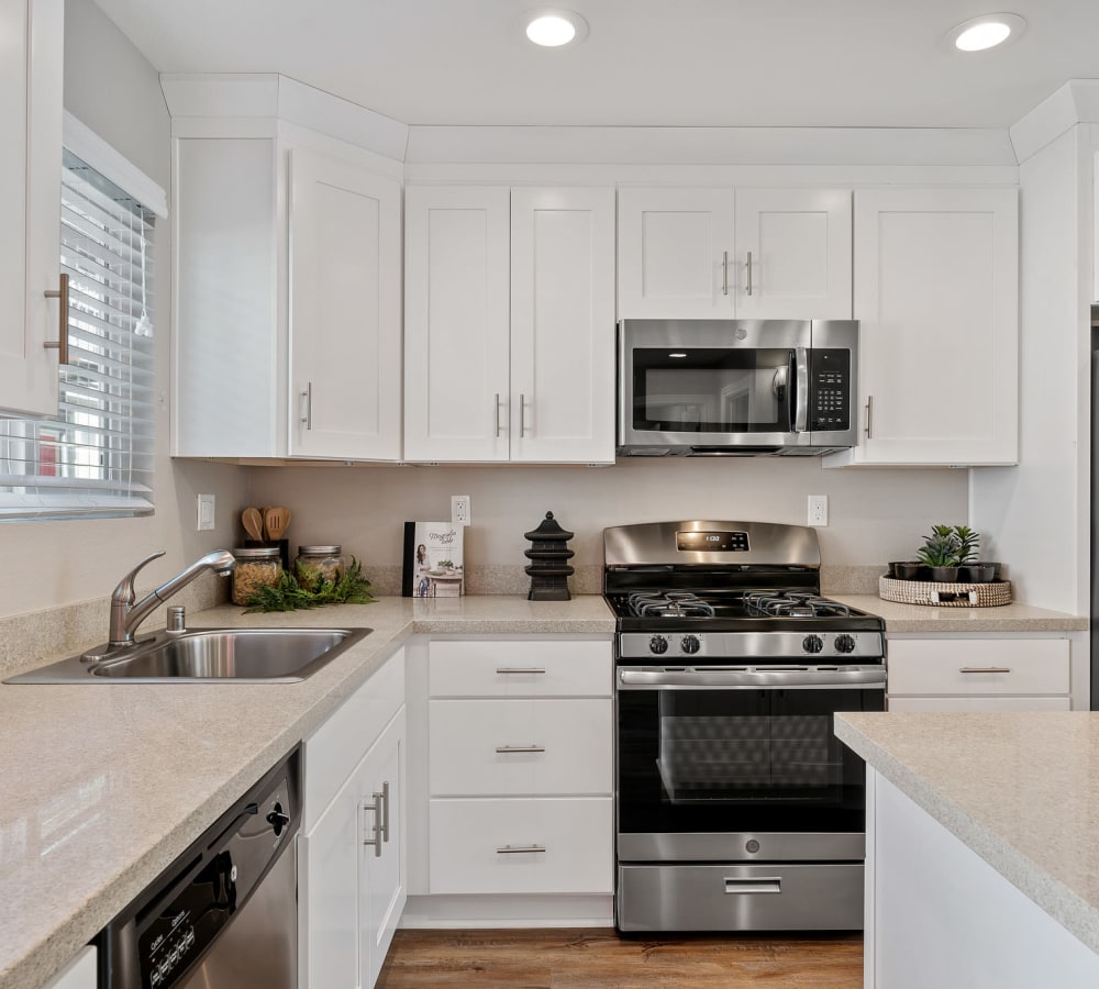 Kitchen island and bright white cabinetry at Pinebrook Apartment Homes in Fremont, California
