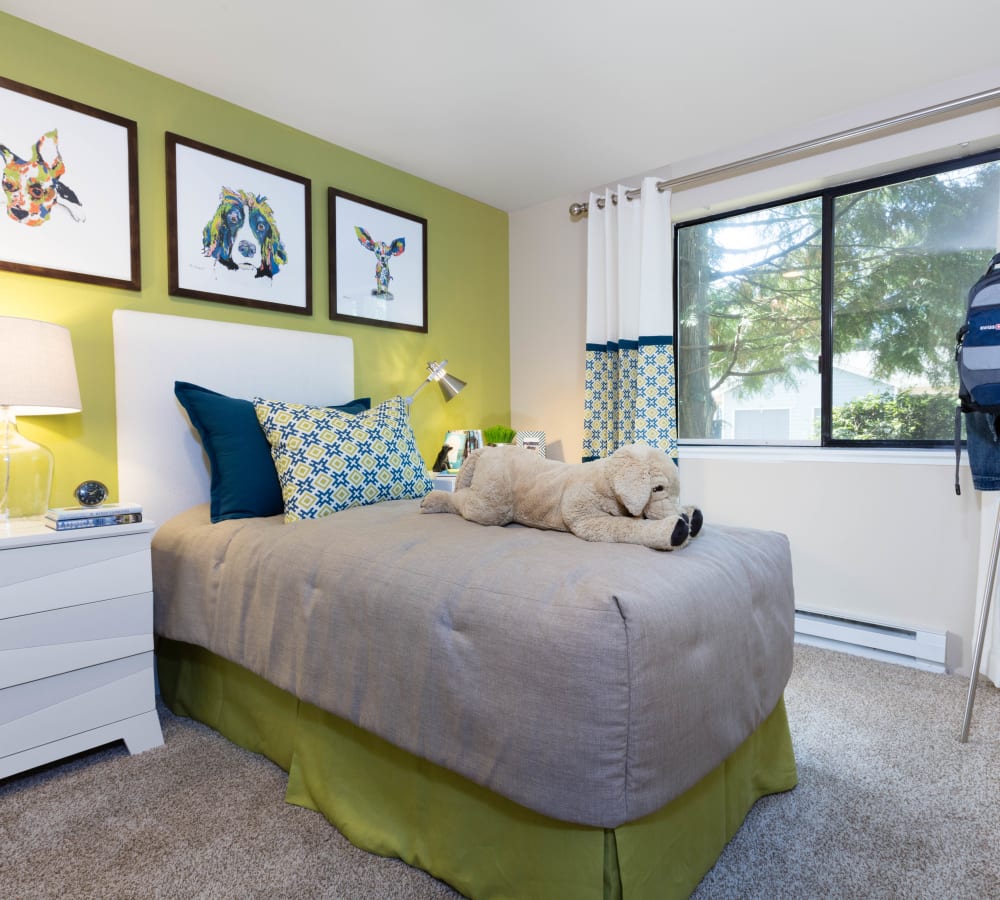 Plush carpeting and draped windows in a model home's bedroom at Madison Sammamish Apartments in Sammamish, Washington