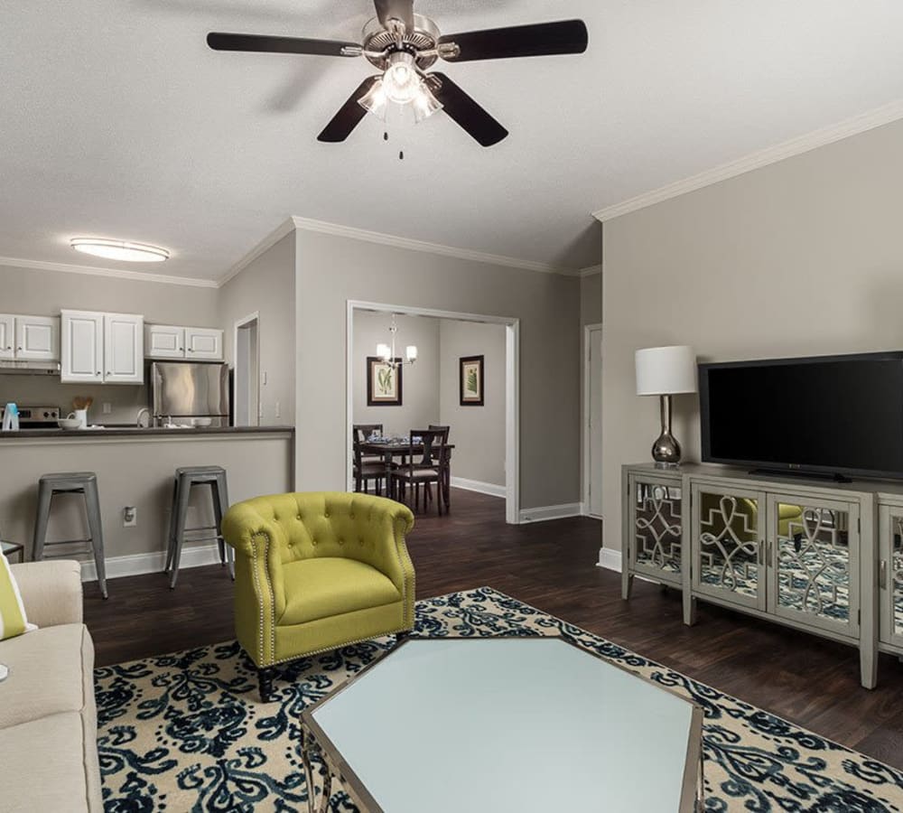 A furnished living room with the kitchen and dining room in the background at Brighton Park in Byron, Georgia