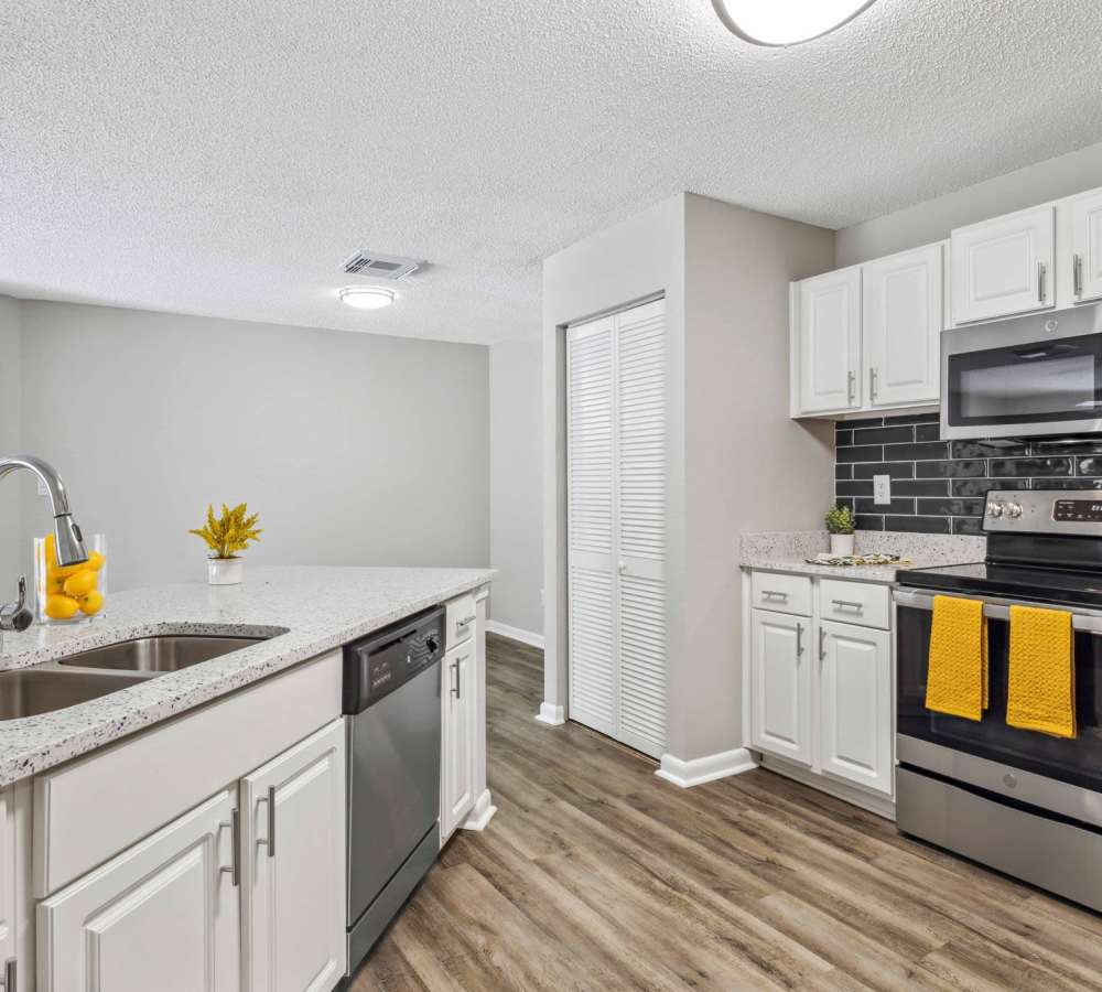 White cabinets and stainless steel appliances in a model kitchen at Mode at Ballast Point in Tampa, Florida