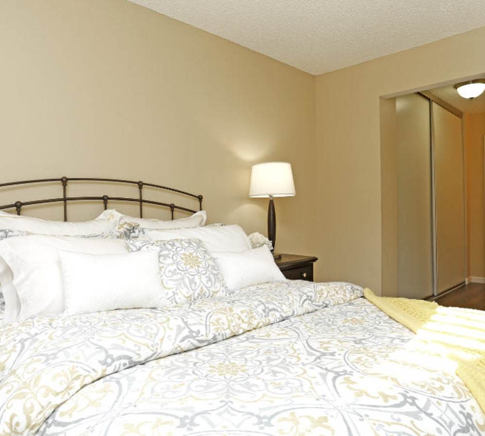 Bedroom with a bed and night stand at Muirwood Apartment Homes in Martinez, California