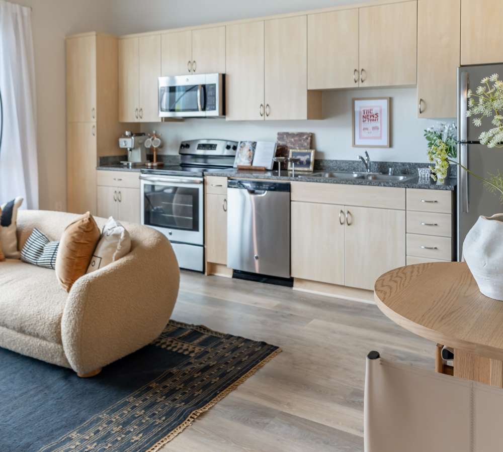 Updated kitchen with stainless steel appliances, including refrigerator and dishwasher at Nova Apartment Homes in San Diego, California