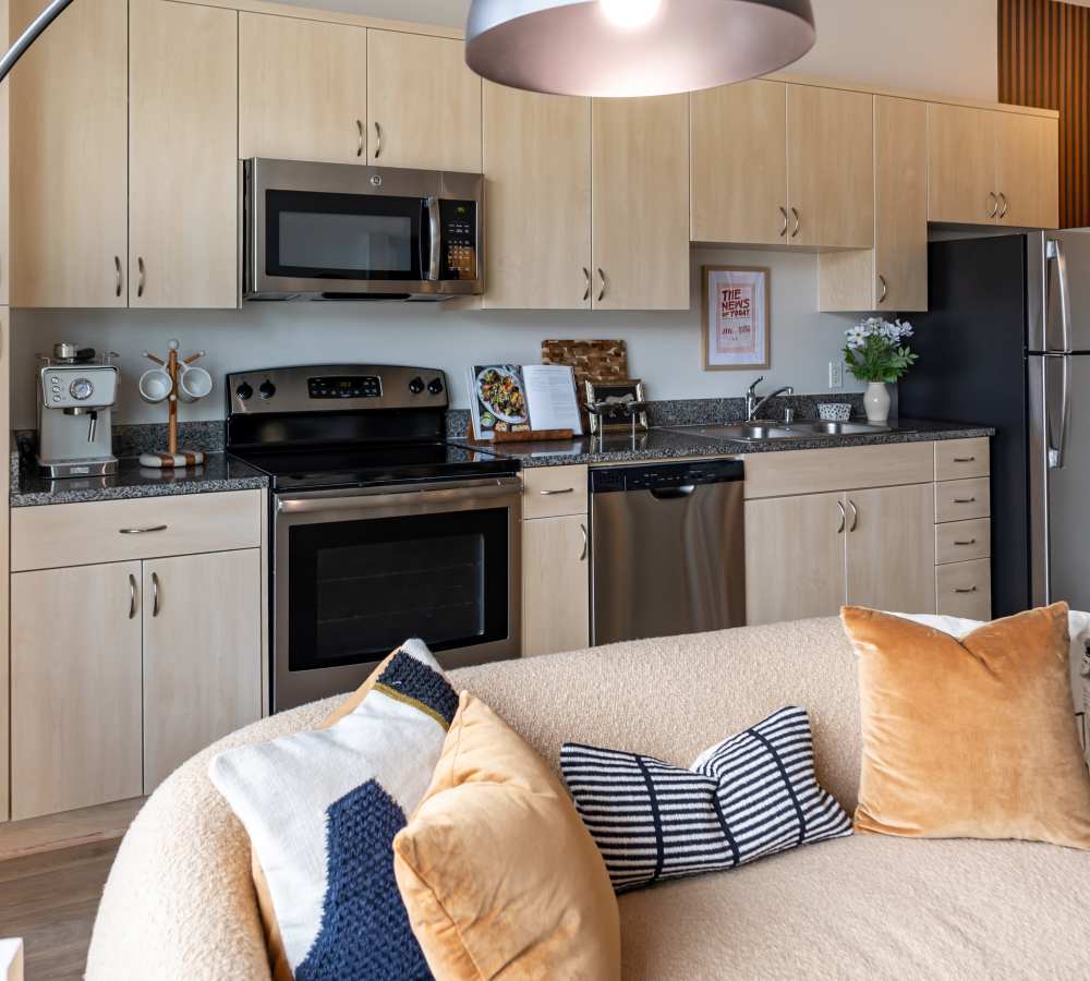 Updated kitchen with stainless steel appliances, including refrigerator and dishwasher at Nova Apartment Homes in San Diego, California