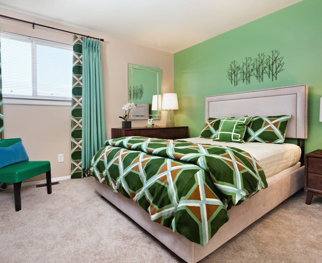 Model bedroom with plush carpeting and an accent wall at James River Pointe in Richmond, Virginia
