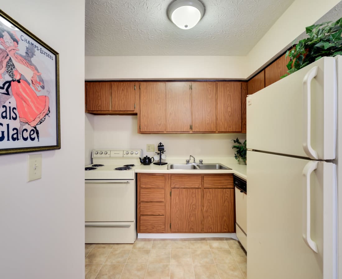 Well designed  kitchen with white appliances and light natural wood cabinets  at Pointe at Northern Woods in Columbus, Ohio