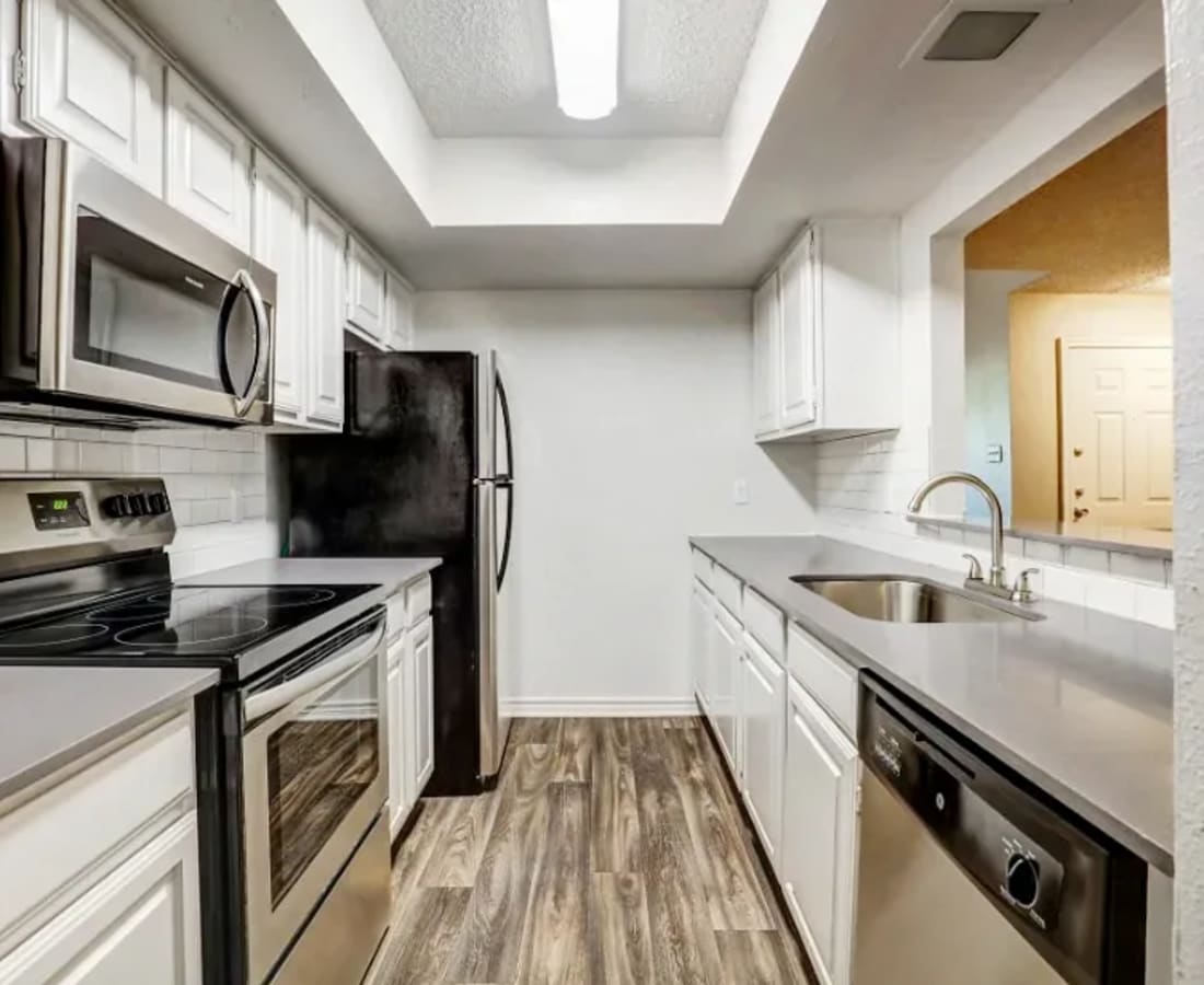 Model kitchen with cabinets at Embry Apartments in Carrollton, Texas
