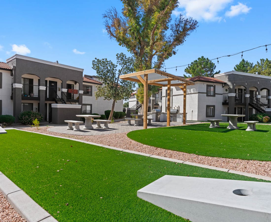 Outside area with corn hole and outside seating at Aventura Apartments in Tucson, Arizona