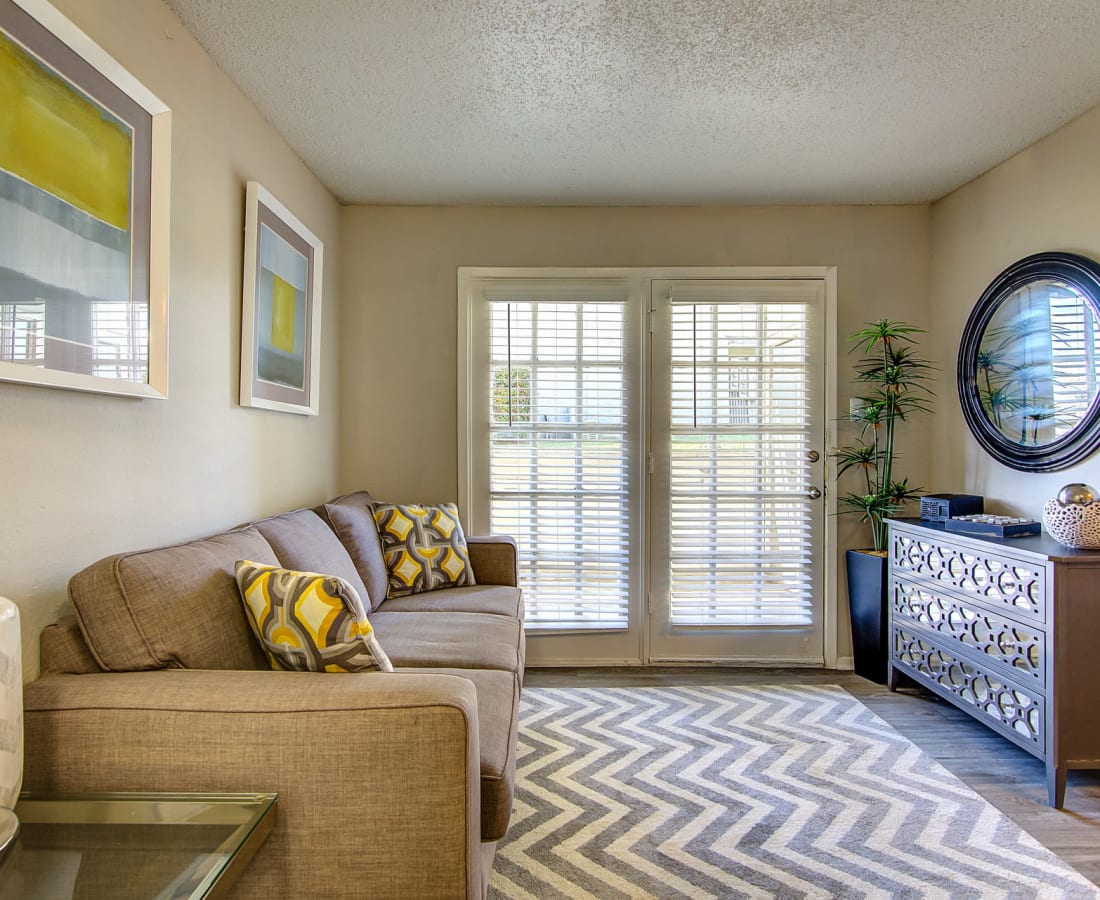 Apartment living room with doors out to a private balcony at Canyon Grove in Grand Prairie, Texas
