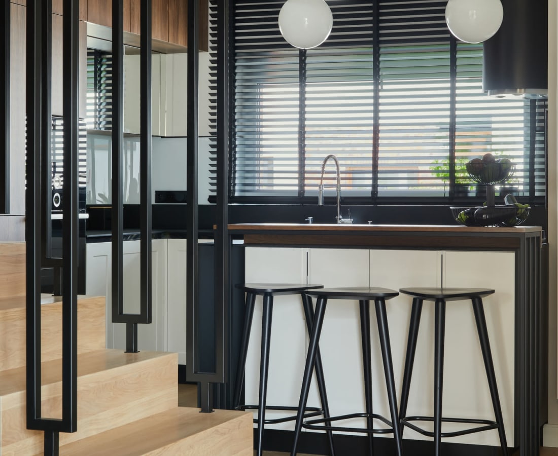 Modern kitchen with bar seating in a luxury model home at Cypress Creek at South Cedar in Temple, Texas