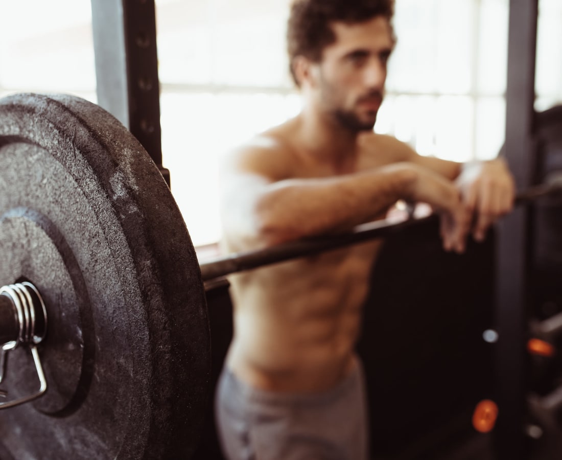 Resident working out at the squat rack in the fitness center at Cypress Creek at South Cedar in Temple, Texas