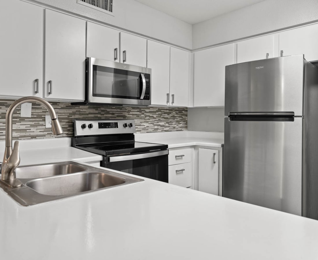 Open layout kitchen with stainless-steel appliances and hardwood floors at Sedona Ridge in Las Vegas, Nevada