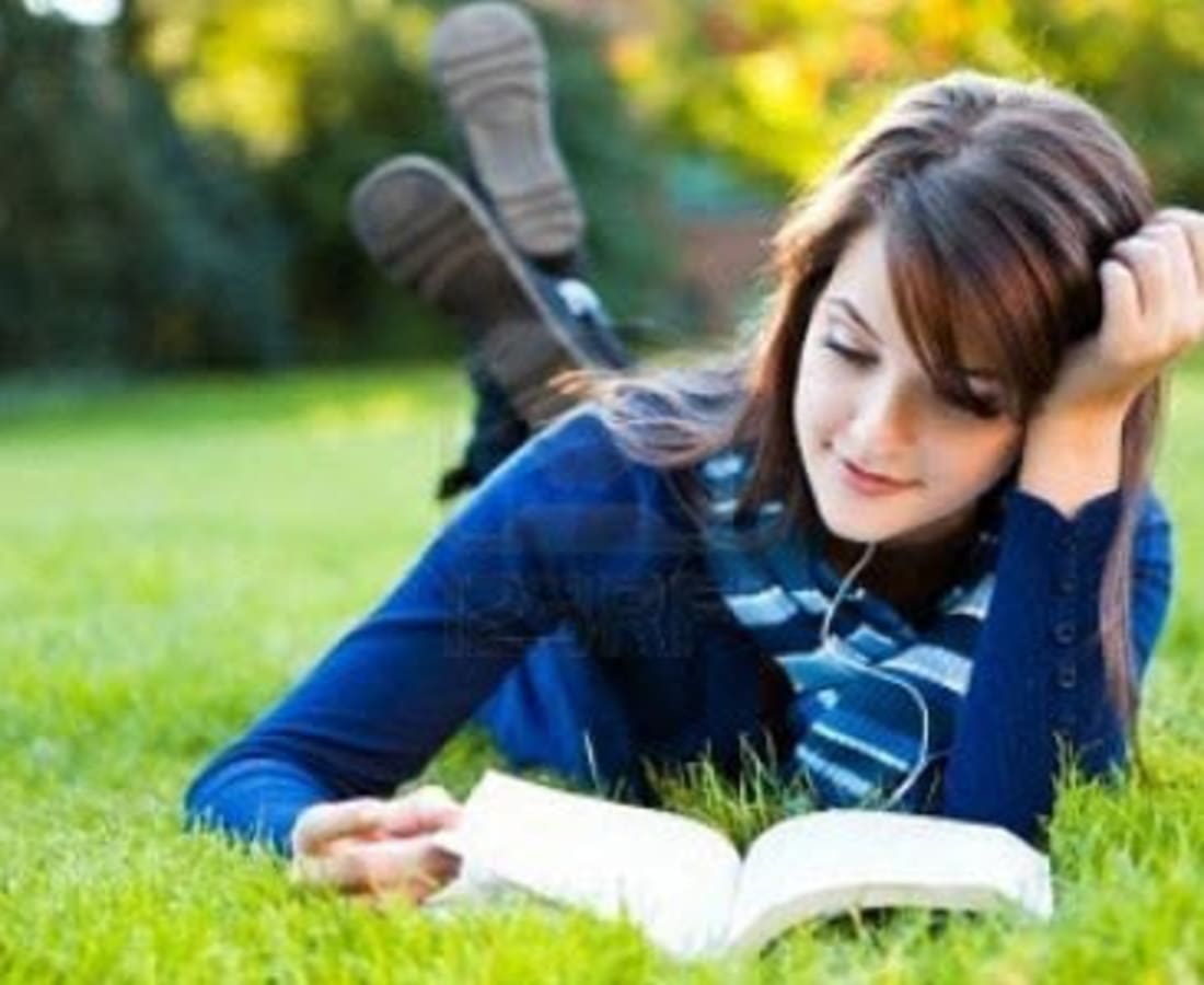 Woman reading a book in park near DaVinci Apartments in Davis, California