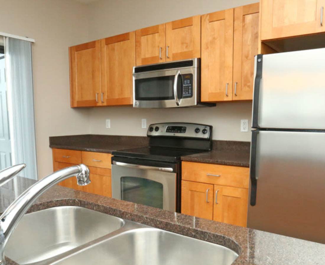 Apartment kitchen space with upgraded appliances at Stadium District Apartments in Lansing, Michigan