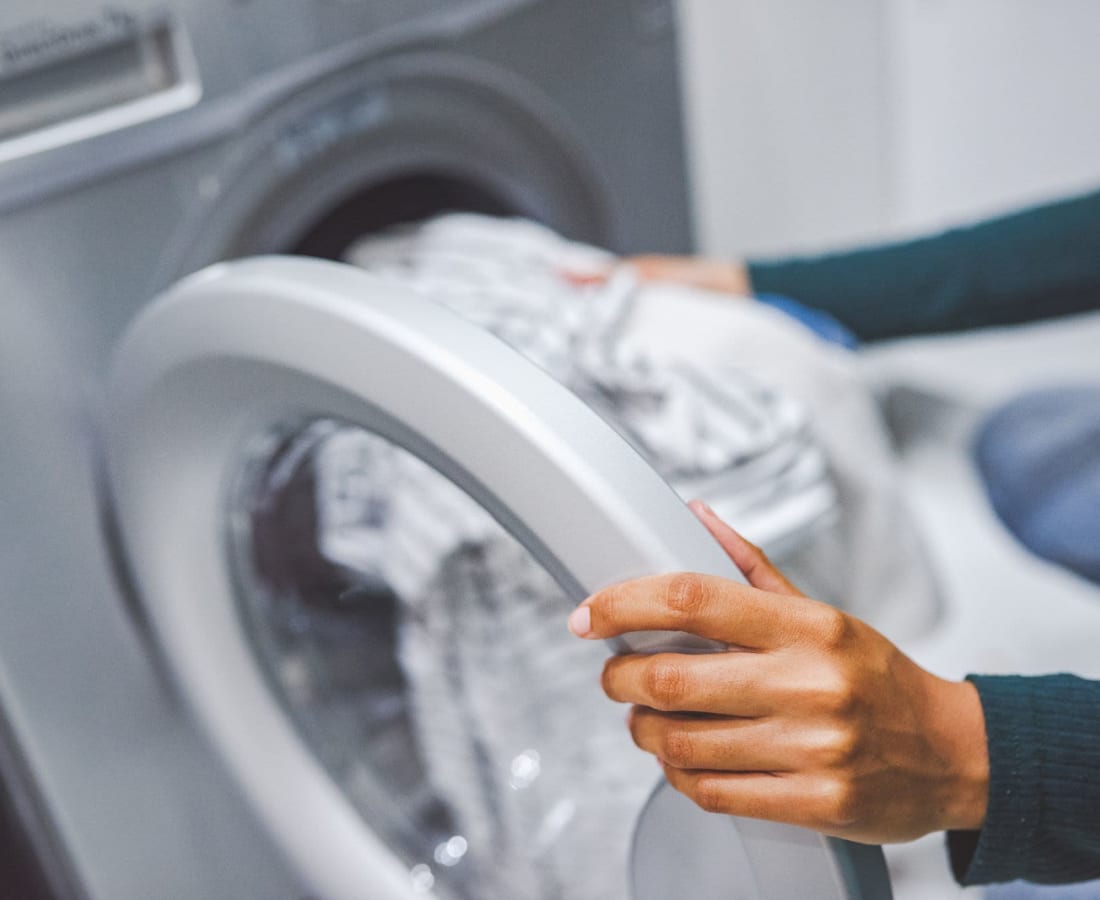 Woman doing washing her cloth in laundry room at DaVinci Apartments in Davis, California