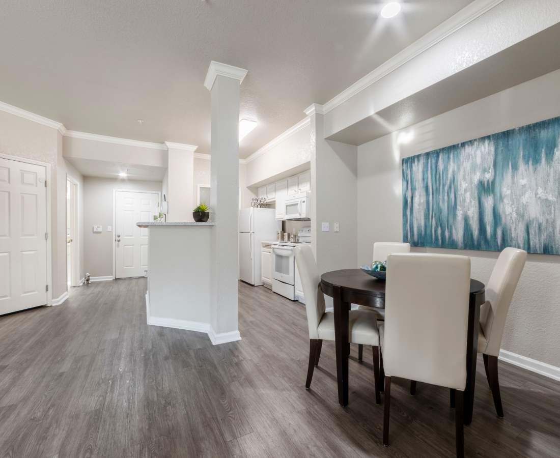 Dining area and kitchen with wood-style flooring at Oak Brook Apartments in Rancho Cordova, California