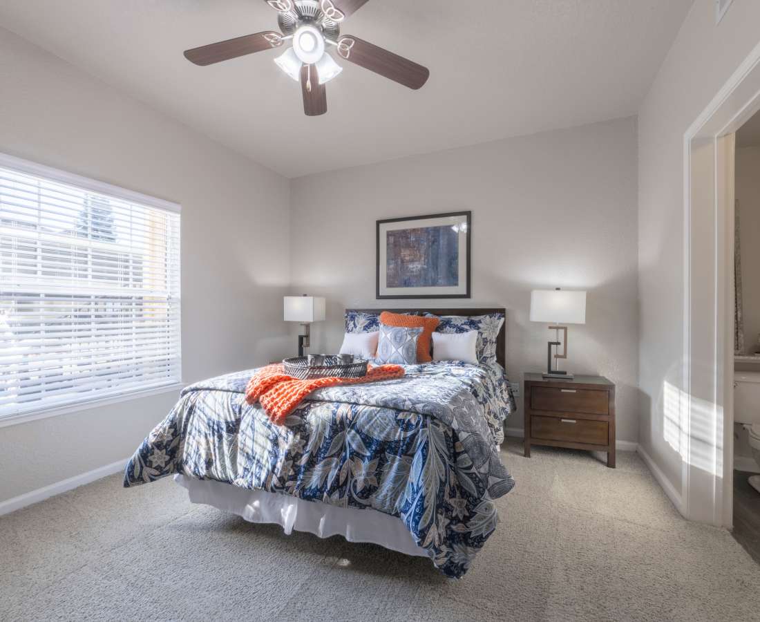 Bedroom with a large window at Oak Brook Apartments in Rancho Cordova, California