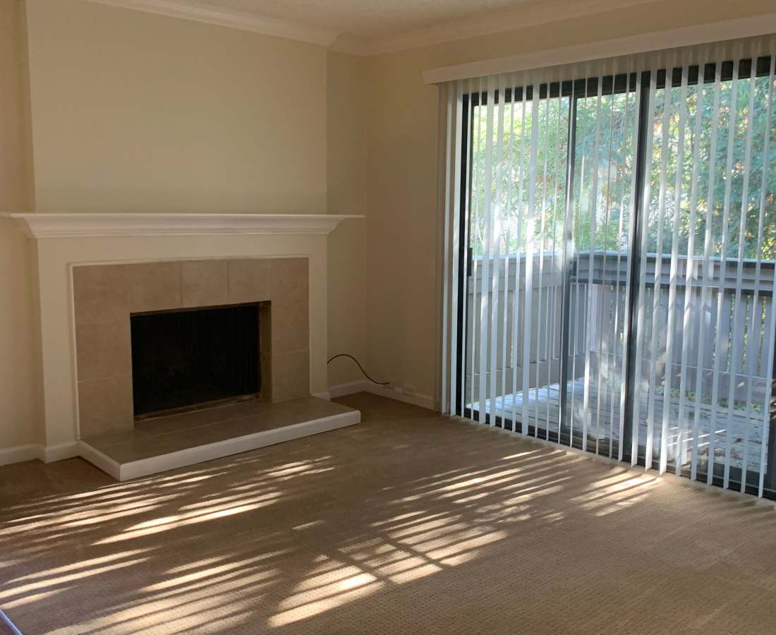 Living room with a fireplace and private balcony attached at Waters Edge in Sacramento, California