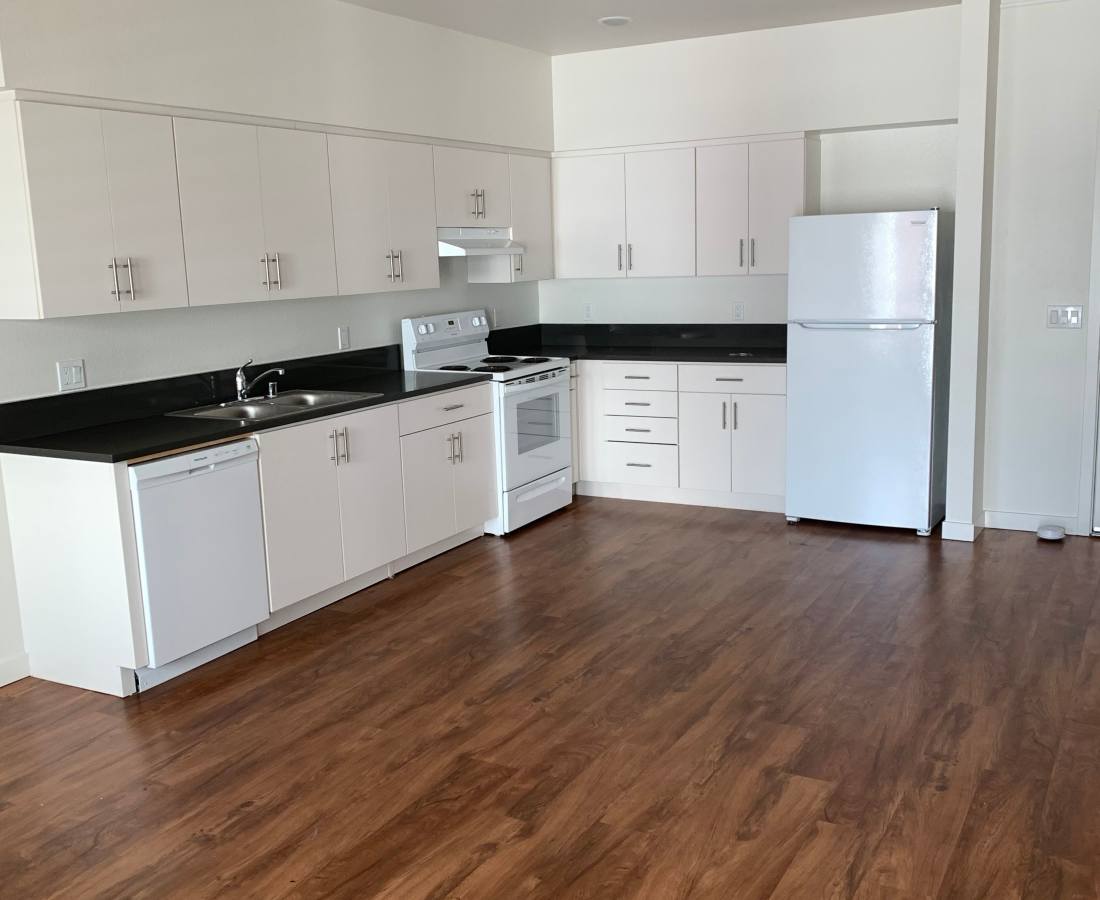 Kitchen with wood-styled flooring at Valencia Pointe in San Diego, California