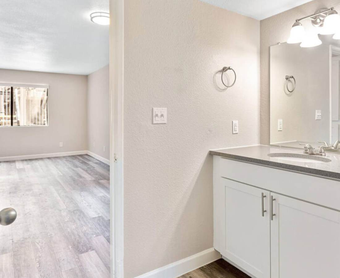 Bright bathroom with mirror and storage space at Raystone Apartments in Phoenix, Arizona