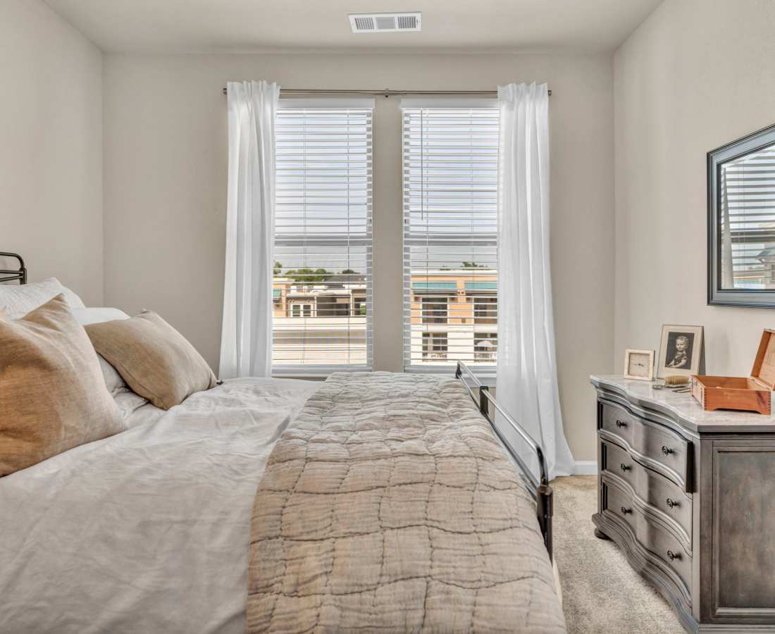 Minimalist furnishings in a model home's bedroom at Mariposa Communications Parkway in Plano, Texas