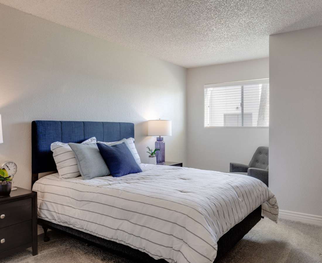 Bedroom with comfortable bed, plush carpet floor and window at 544 Southern Apartments in Mesa, Arizona