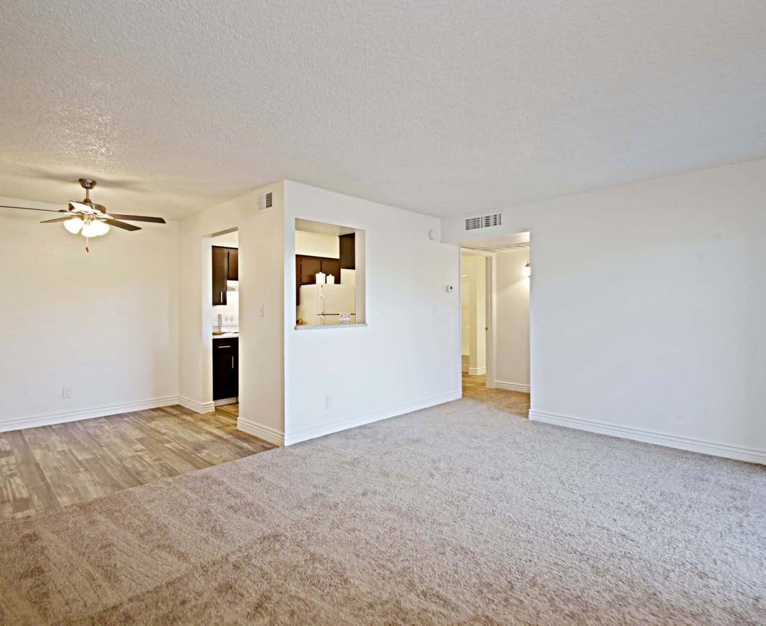 Open layout living room with carpeted flooring and close access to dining and kitchen at 544 Southern Apartments in Mesa, Arizona