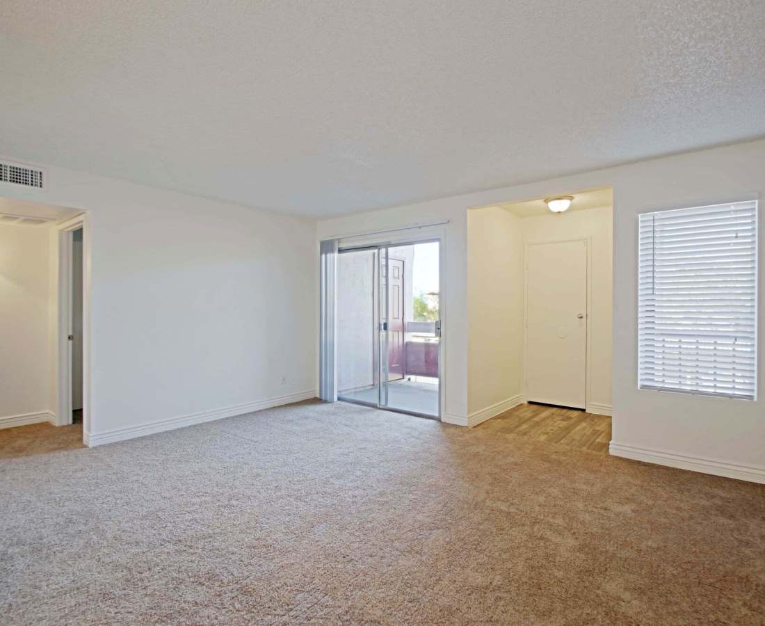 Open concept and spacious living room with window and door leading to private balcony at 544 Southern Apartments in Mesa, Arizona