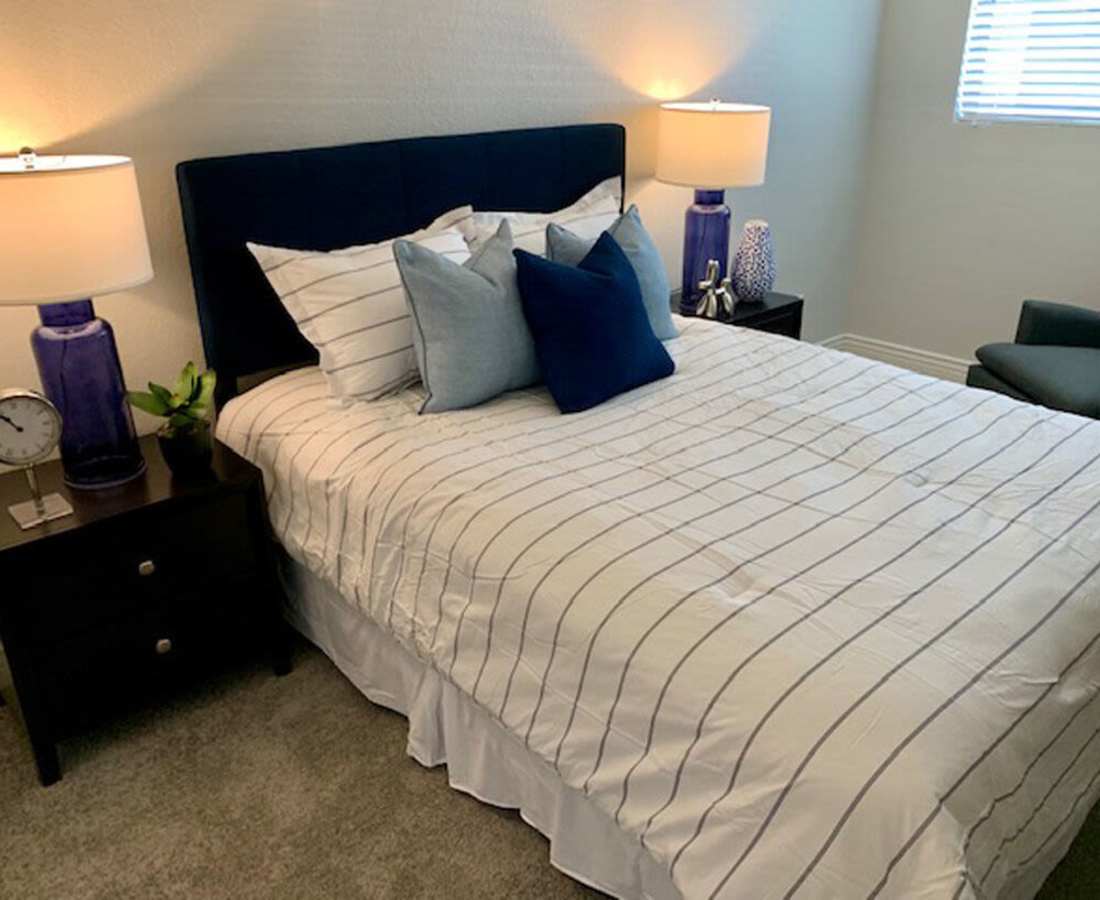 Bedroom with large bed and bed side lamps at 544 Southern Apartments in Mesa, Arizona