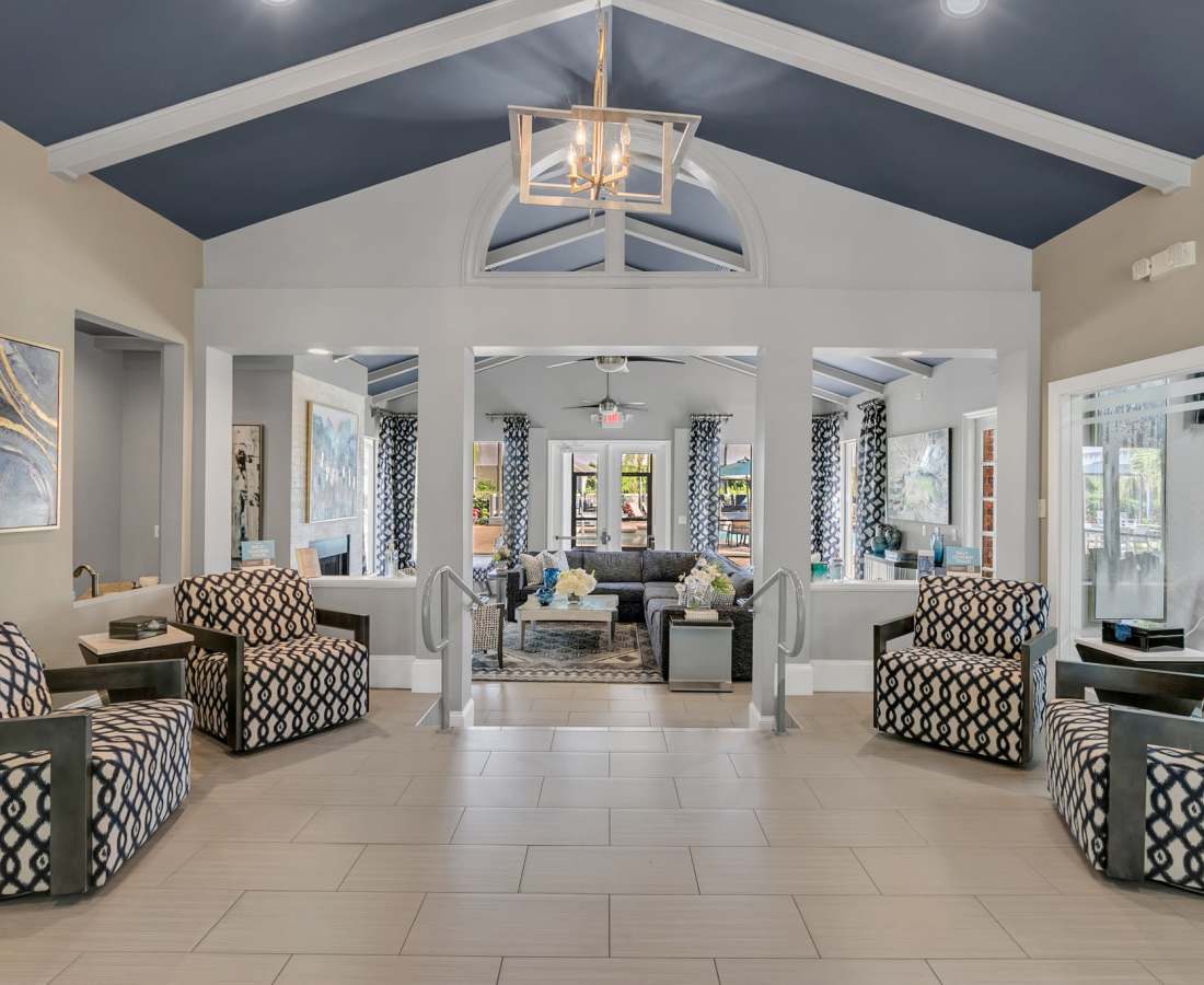 Clubhouse with multiple armchairs and large windows across the room at Rosemont Windermere in Orlando, Florida