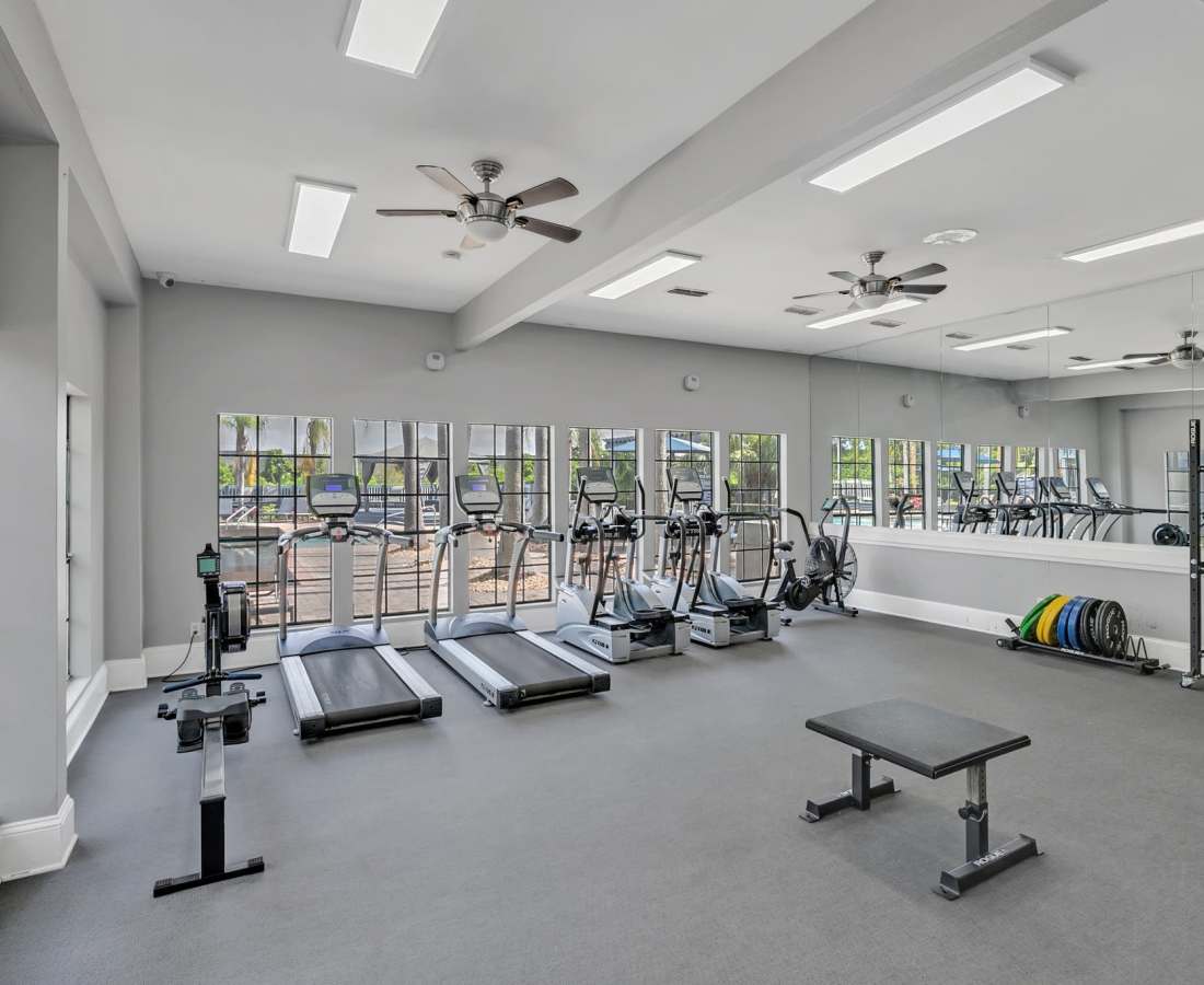Well-equipped fitness center with multiple treadmills, ceiling fan and a large mirror at Rosemont Windermere in Orlando, Florida