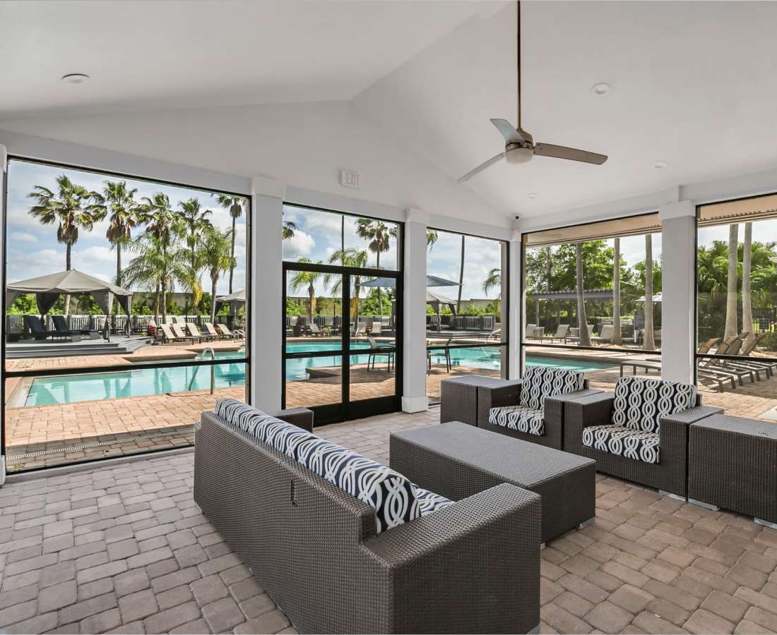 Community waiting area with a couch, coffee table and large windows at Rosemont Windermere in Orlando, Florida
