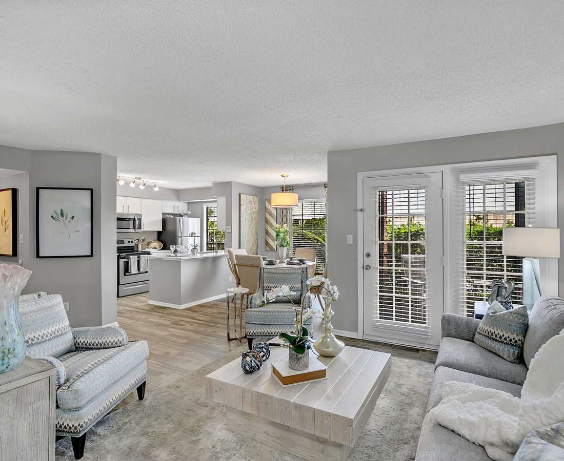 Spacious living room with a couch, coffee table, multiple windows and an open kitchen at Rosemont Windermere in Orlando, Florida