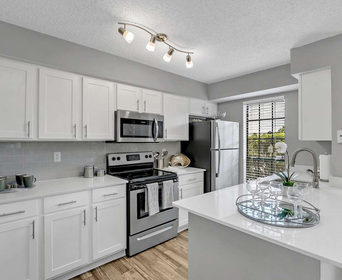 Modern kitchen with wooden cabinets, stainless-steel appliances, wooden flooring and a refrigerator at Rosemont Windermere in Orlando, Florida