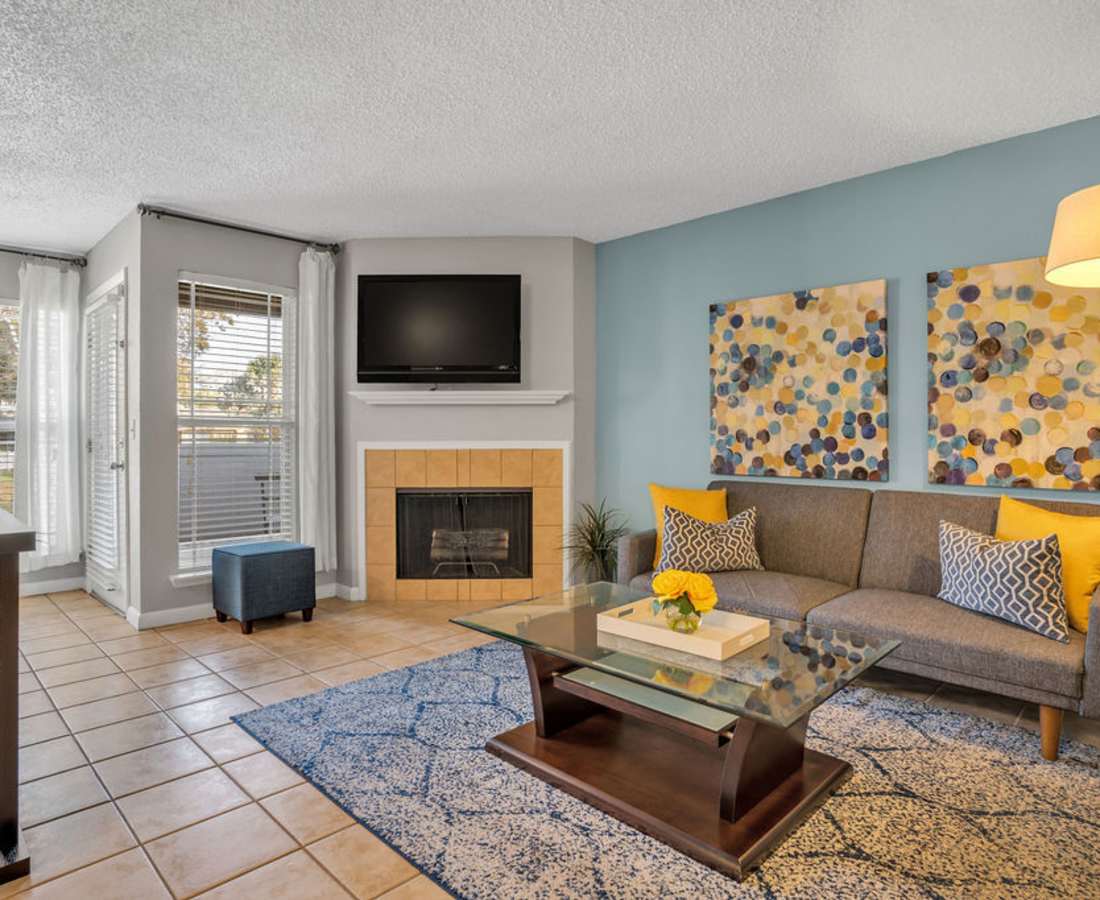 Living room with television and table at The Canopy Apartment Villas in Orlando, Florida
