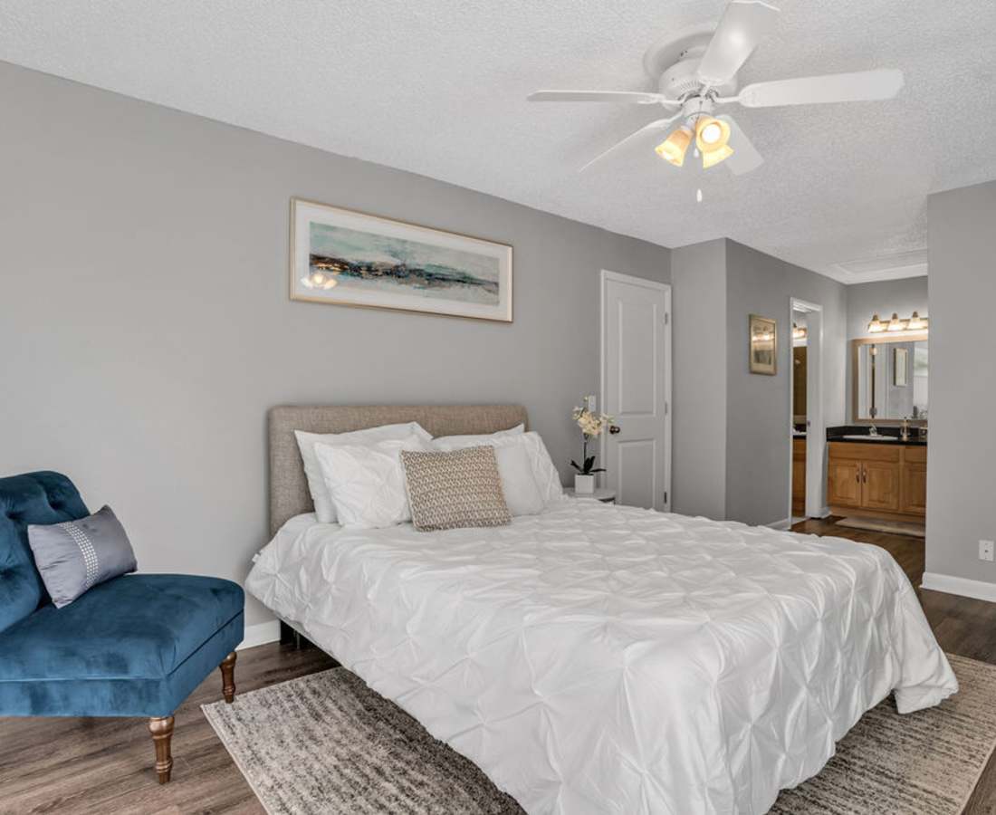 Bedroom with a chair in the side at The Canopy Apartment Villas in Orlando, Florida