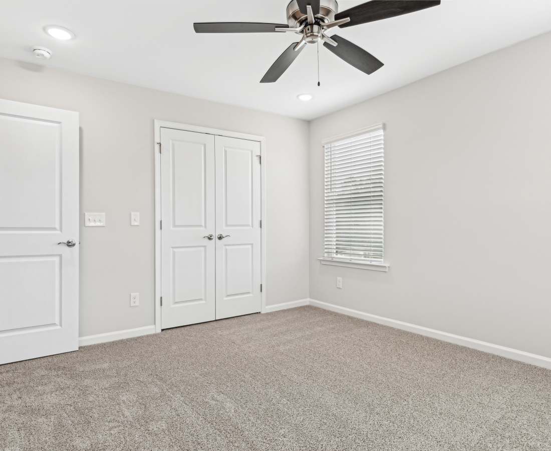 Spacious bedroom with ceiling fan and closet space at Westmont Village in Charlotte, North Carolina