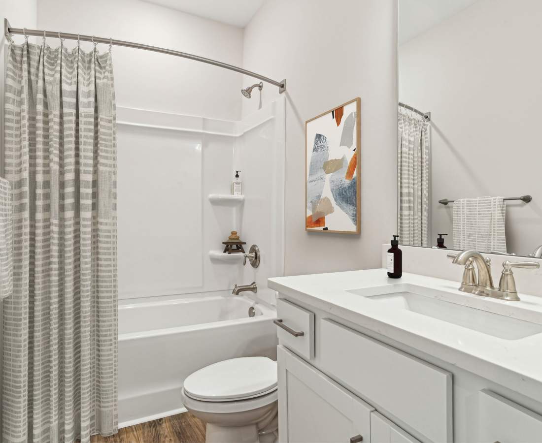 Bright bathroom with sink, mirror, and storage space at Westmont Village in Charlotte, North Carolina