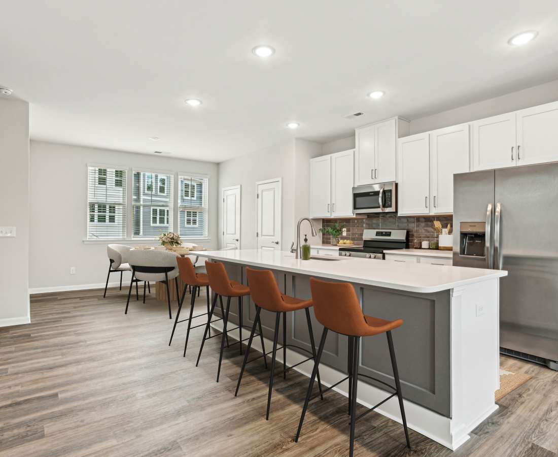 Kitchen with breakfast counter, bar stools and whit ecabinets at Westmont Village in Charlotte, North Carolina
