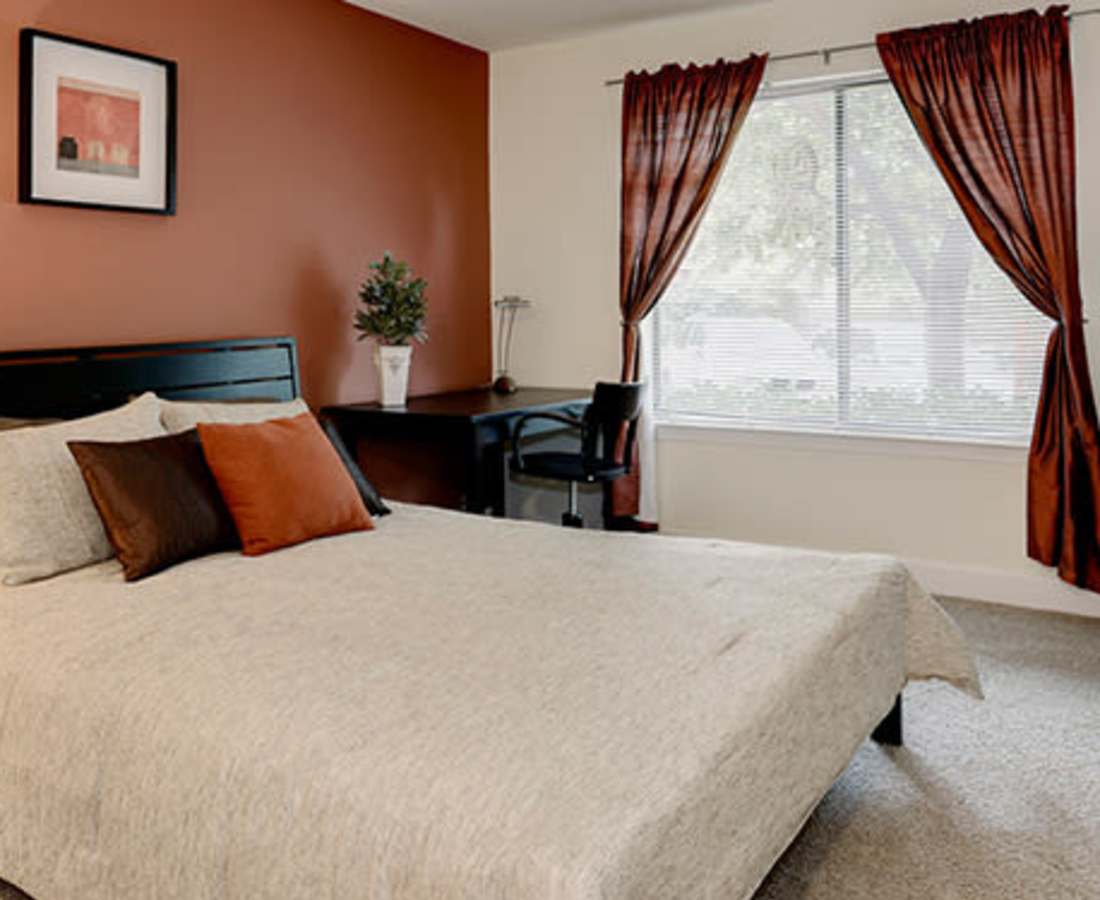 Bed with decorative pillows and desk at Bethesda Hill in Bethesda, Maryland