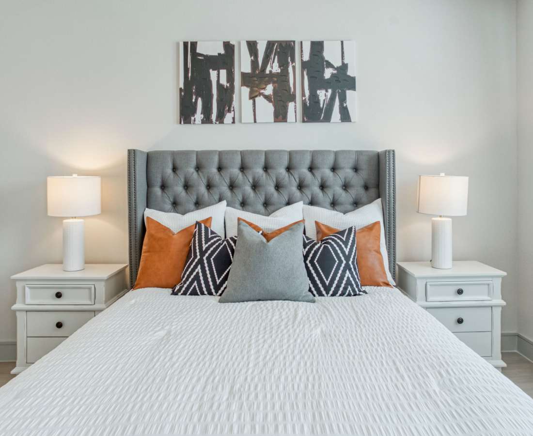 Gray tufted headboard with decorative pillows at Dakota at Shepherd in Houston, Texas