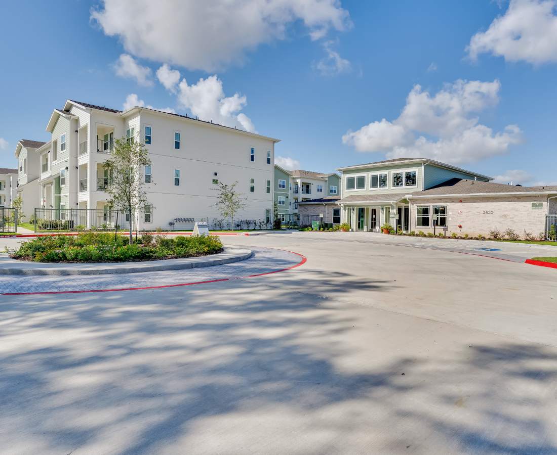 Modern apartment buildings with landscaped entrance at Meridian City Park in Houston, Texas