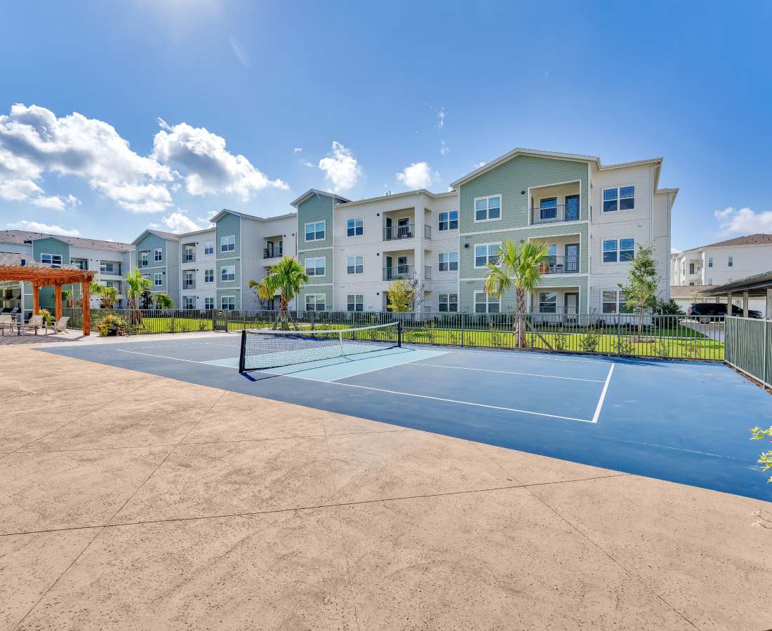 Tennis court surrounded by greenery at community at Meridian City Park in Houston, Texas