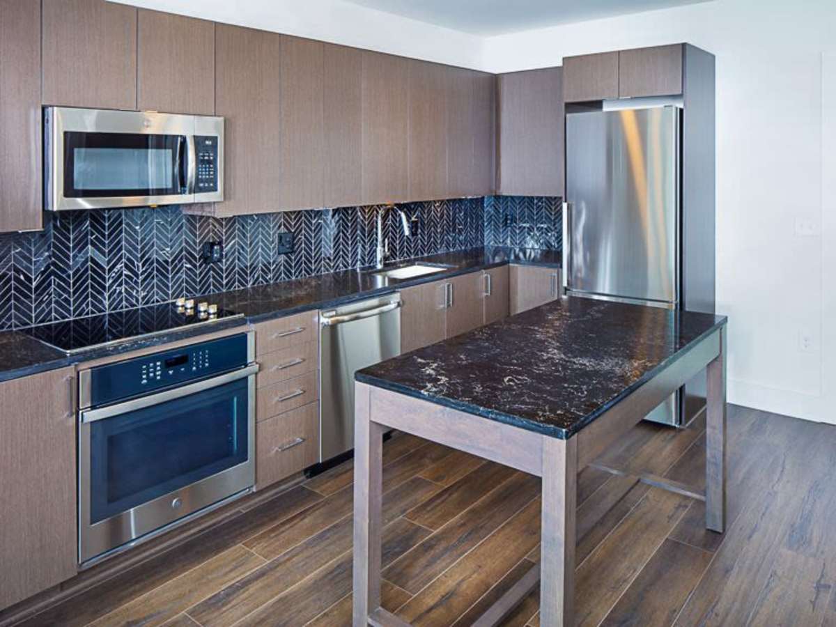 Chevron tile backsplash and an island in a kitchen at J Linea in Washington, District of Columbia