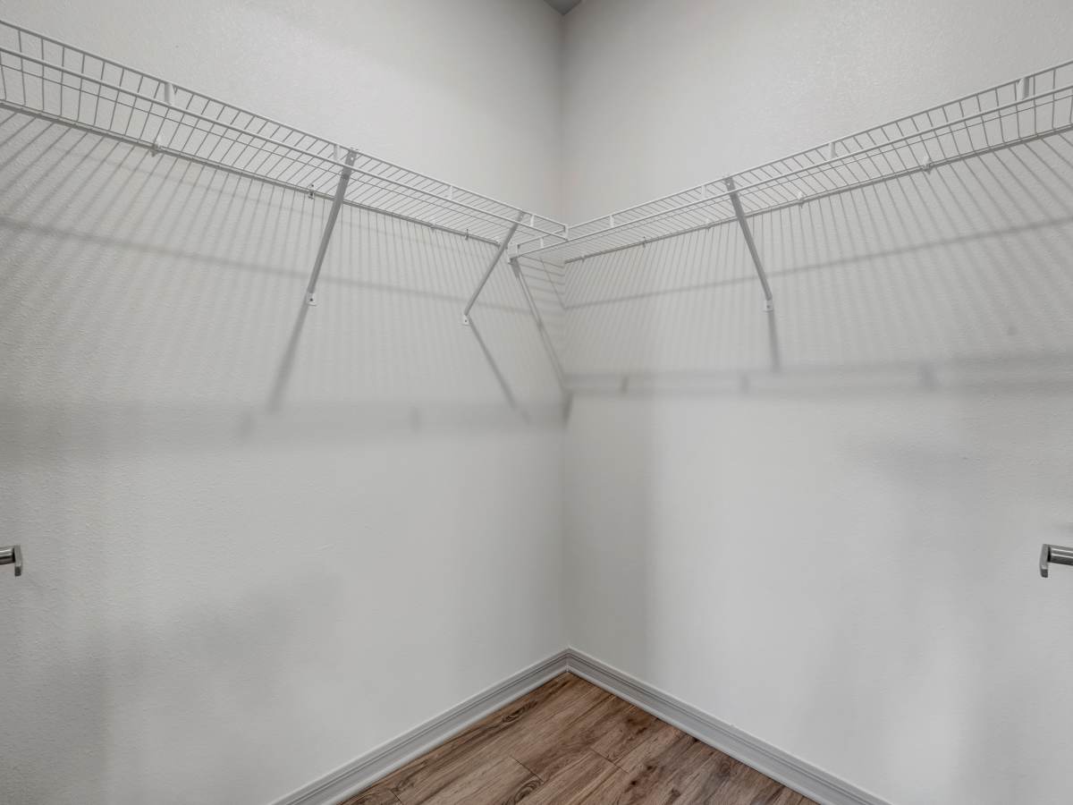 Spacious walk-in closet with wire shelving and wood-style flooring at The Carlton of West Melbourne in West Melbourne, Florida
