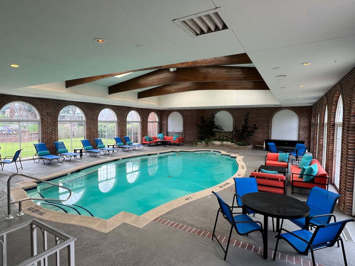 Indoor pool with seating area around  at Georgetown Apartments in Merriam, Kansas