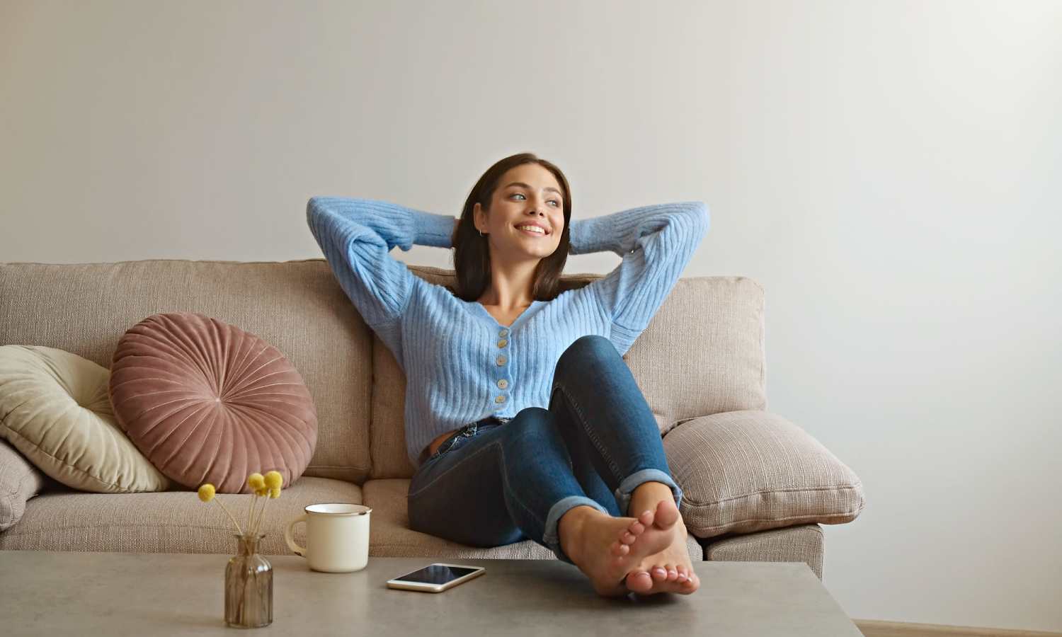 Woman relaxing on a couch in her apartment at Red Knot at Edinburgh in Chesapeake, Virginia