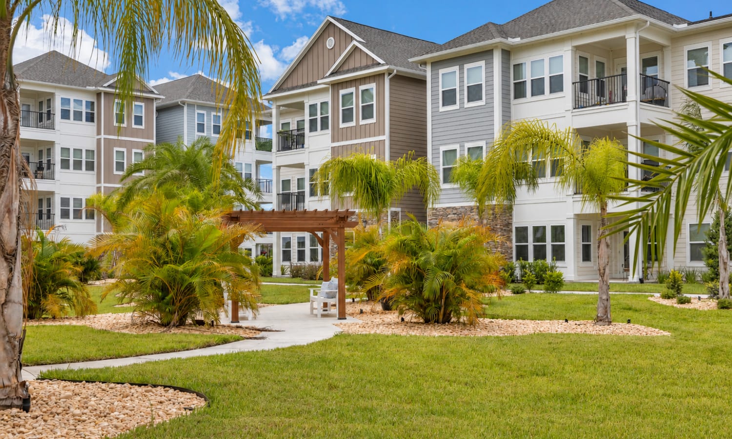 Landscaped courtyard with seating and walking path at The Carlton At Lake Dexter in Winter Haven, Florida