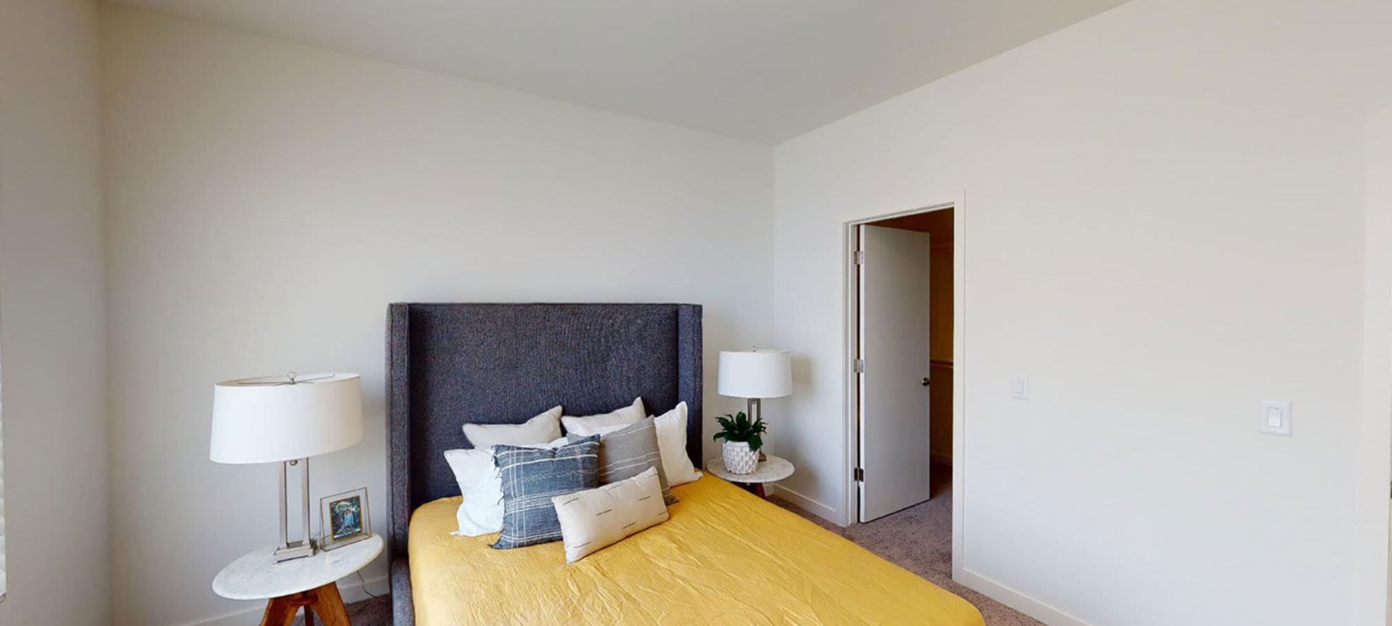 Model bedroom with yellow bed at Novella at Biltmore in Phoenix, Arizona