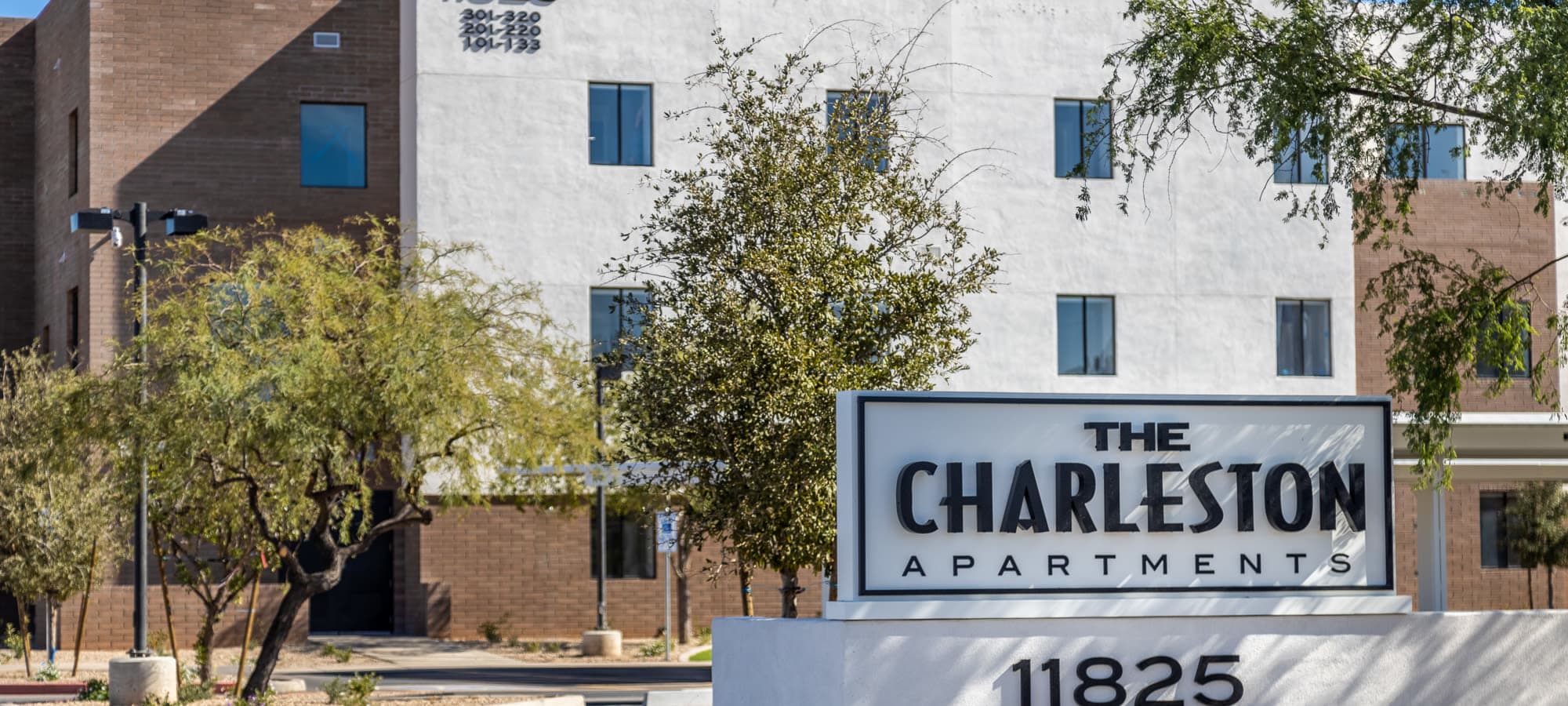Entrance sign in front of the building at The Charleston Apartments in Phoenix, Arizona