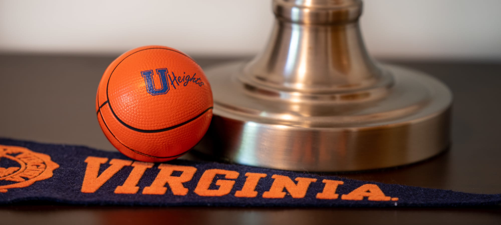 A small basketball with a college pennant next to it on a desk University Heights in Charlottesville, Virginia